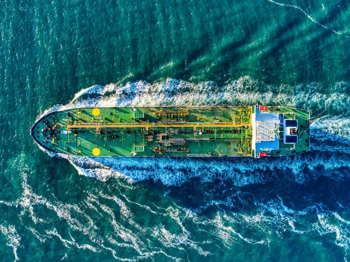 Green oil tanker headed out to sea aerial