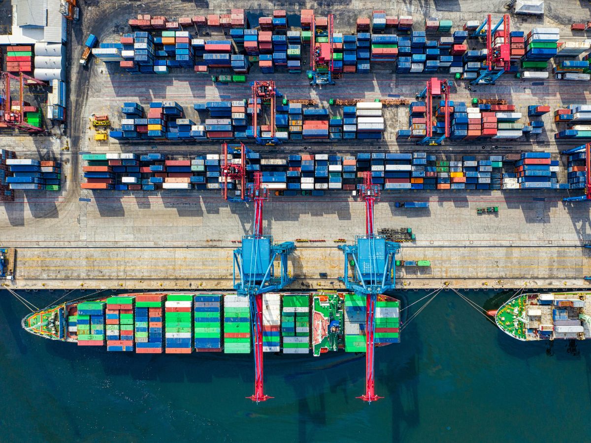 Shipping containers in a port with a boat.