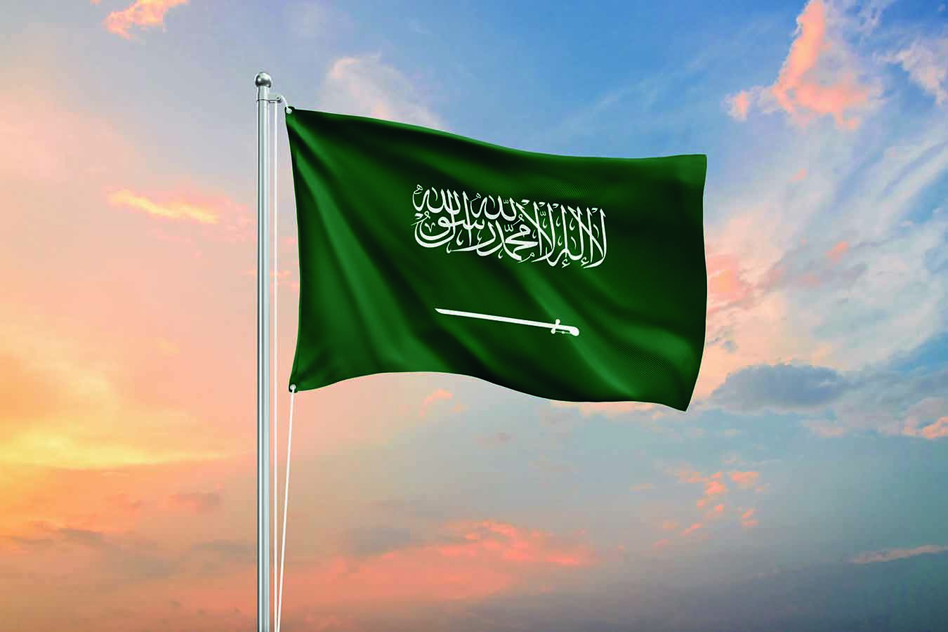 Saudi Arabia flag waving on sundown sky